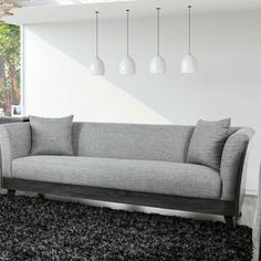 a gray couch sitting on top of a black rug