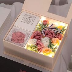 an open box with flowers inside sitting on a table