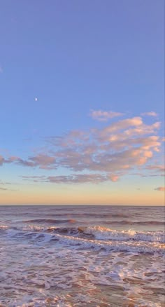 a person riding a surfboard on top of a wave in the ocean at sunset