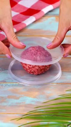 two hands reaching for a hamburger in a plastic container