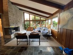 a living room filled with furniture next to a fire place under a vaulted skylight