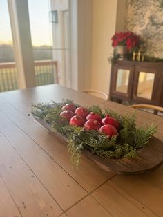 apples are arranged in a wooden bowl on a table