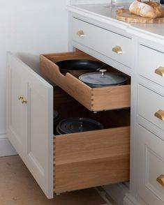 two pots and pans are sitting in the cabinet drawer on the side of the counter