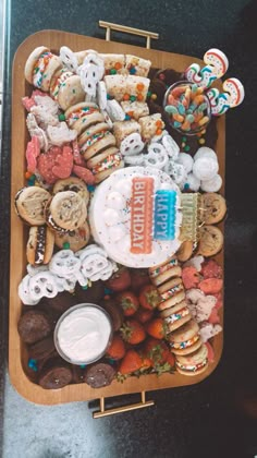 a tray filled with lots of different types of cookies and pastries on top of a table