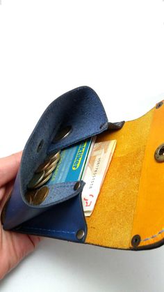 a hand holding a wallet with two credit cards in it and another card holder attached to the pocket