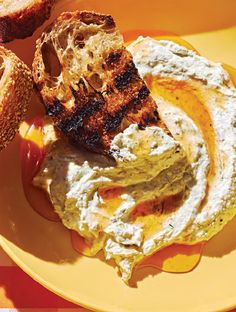 grilled meat and vegetables on a yellow plate with mustard, sour cream and bread