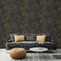 a living room with a couch, coffee table and ottoman in front of a wallpapered background