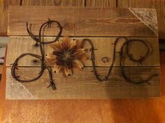 a wooden sign that says love with flowers on it