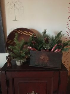 a wooden cabinet with a potted plant sitting on top of it next to a clock