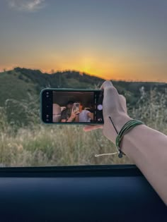 a person taking a photo with their cell phone in the back seat of a car