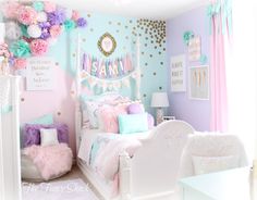 a bedroom decorated in pastel colors with pink, blue and gold decorations on the walls