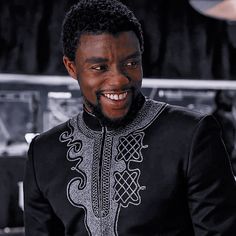 a man in a black and silver outfit smiling