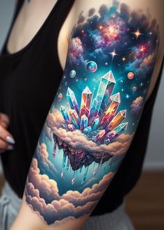 a woman's arm with an image of crystals on the clouds and stars in the sky