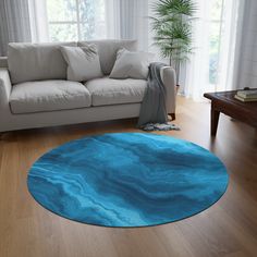 a living room with a white couch and blue area rug on the wooden flooring