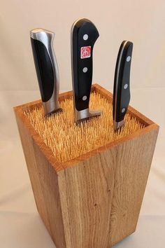 three knives in a wooden holder on a white background