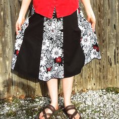 "Here is a classy looking black, white and red knee length skirt for women. Made with two coordinating cotton fabrics, this handmade a-line skirt is perfect for many different occasions! This skirt has 8 panels alternating between a solid black fabric and a white print with black outlined flowers and bold red accents here and there to add a little bit of color. Depending on the look you want, a black, white, or red top would all look great with this Summer skirt This skirt has an elastic waistba Red Cotton Midi Skirt, Red Cotton Flared Skirt, Black Cotton Knee-length Skirt, Red Flared Cotton Skirt, Black Knee-length Cotton Skirt, Black A-line Retro Skirt, Black Retro A-line Skirt, Black Cotton Skirt With Gathered Details, Black Cotton Flared Skirt