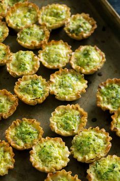 broccoli and cheese tarts on a baking sheet ready to be baked in the oven