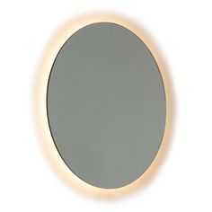 a round mirror with light around it on a white wall above the mirror is a reflection of an individual's face