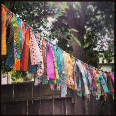 many colorful ties are hanging on a clothes line outside in the sun with trees behind them