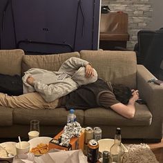 a man laying on top of a couch in a living room