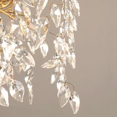 a chandelier hanging from a ceiling with lots of crystal beads and leaves on it