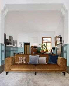 a living room filled with furniture and lots of pillows on top of it's couches