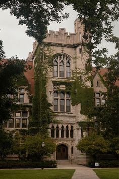 an old building with ivy growing on it's side and trees in the foreground