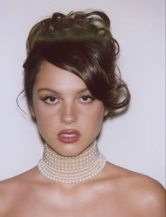 a young woman wearing a pearl necklace and pearls around her neck