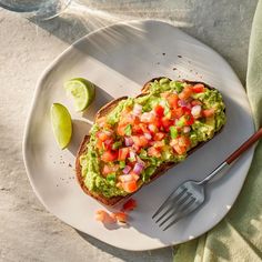 an avocado toast on a plate with a fork