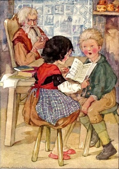 two children sitting at a table with an older man and woman reading to each other