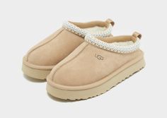 Slip them into premium style with these children's Tazz from UGG. In a Sand colourway, these downsized slippers have a smooth suede upper and an ultra-lush UGGplush lining and insole for moisture-wicking comfort. They're sat above a soft EVA midsole and a sugarcane EVA outsole for extra height and grip. Finished off with UGGbraid detailing on the collar, a woven heel pull and the UGG badge. Uggs Platform Slippers, Ugg Slippers For Kids, Uh Slippers, Cute Shoes Uggs, Small Uggs, Sand Uggs, Beige Uggs, Uggs For Kids, Slip On Uggs