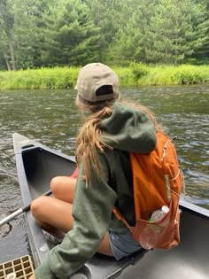 a woman sitting in the back of a boat on a river