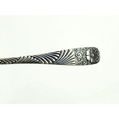 a silver spoon with intricate designs on it's side, against a white background