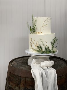 a three layer white cake sitting on top of a wooden table next to a napkin