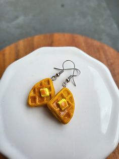 two waffle shaped earrings on a white plate