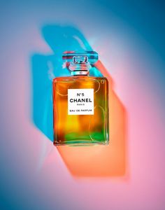 a bottle of chanel no 5 eau de parfum on a blue and pink background