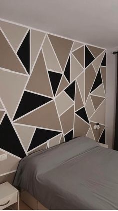 a bed sitting in a bedroom next to a wall with black and white designs on it