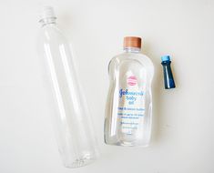 an empty bottle next to a plastic water bottle with a blue cap on the top