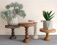 three wooden stools with plants in them sitting on the floor next to each other