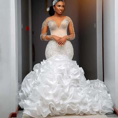 a woman in a wedding dress is standing on the stairs with her arms crossed and looking at the camera