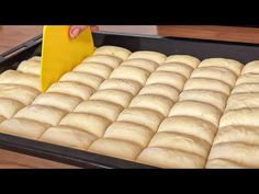 a pan filled with bread sitting on top of a wooden table next to a yellow spatula