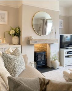 a living room filled with furniture and a fire place in front of a tv mounted on a wall