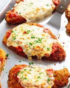 chicken parmesan cut in half on a baking sheet