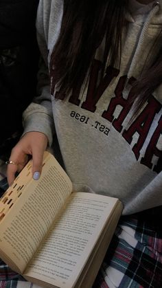 a person sitting down holding an open book