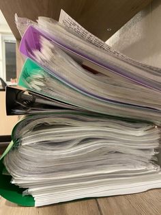 a stack of papers sitting on top of a wooden table