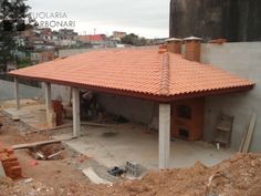 a house under construction with a red tiled roof