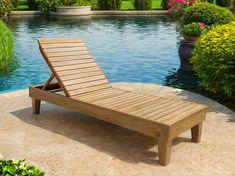 a wooden chaise lounger sitting on top of a patio next to a pool