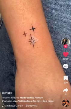 a small tattoo with three stars on the side of the arm and an arrow in the middle