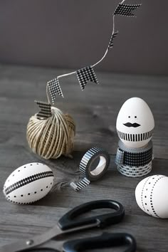 an assortment of crafting supplies including scissors, yarn and eggs on a wooden table