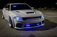 the front end of a white car with blue lights